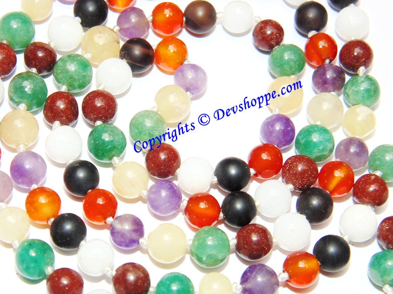 Close-up of multicolor chakra prayer beads: white, green, purple, orange, red, black