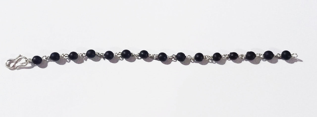 Black Vaijanti bead bracelet laid flat with silver-toned chain and clasp