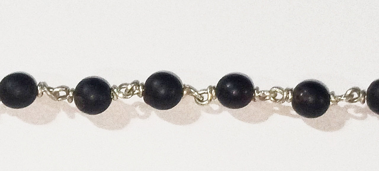 Black round bead bracelet with silver chain links and metal connector