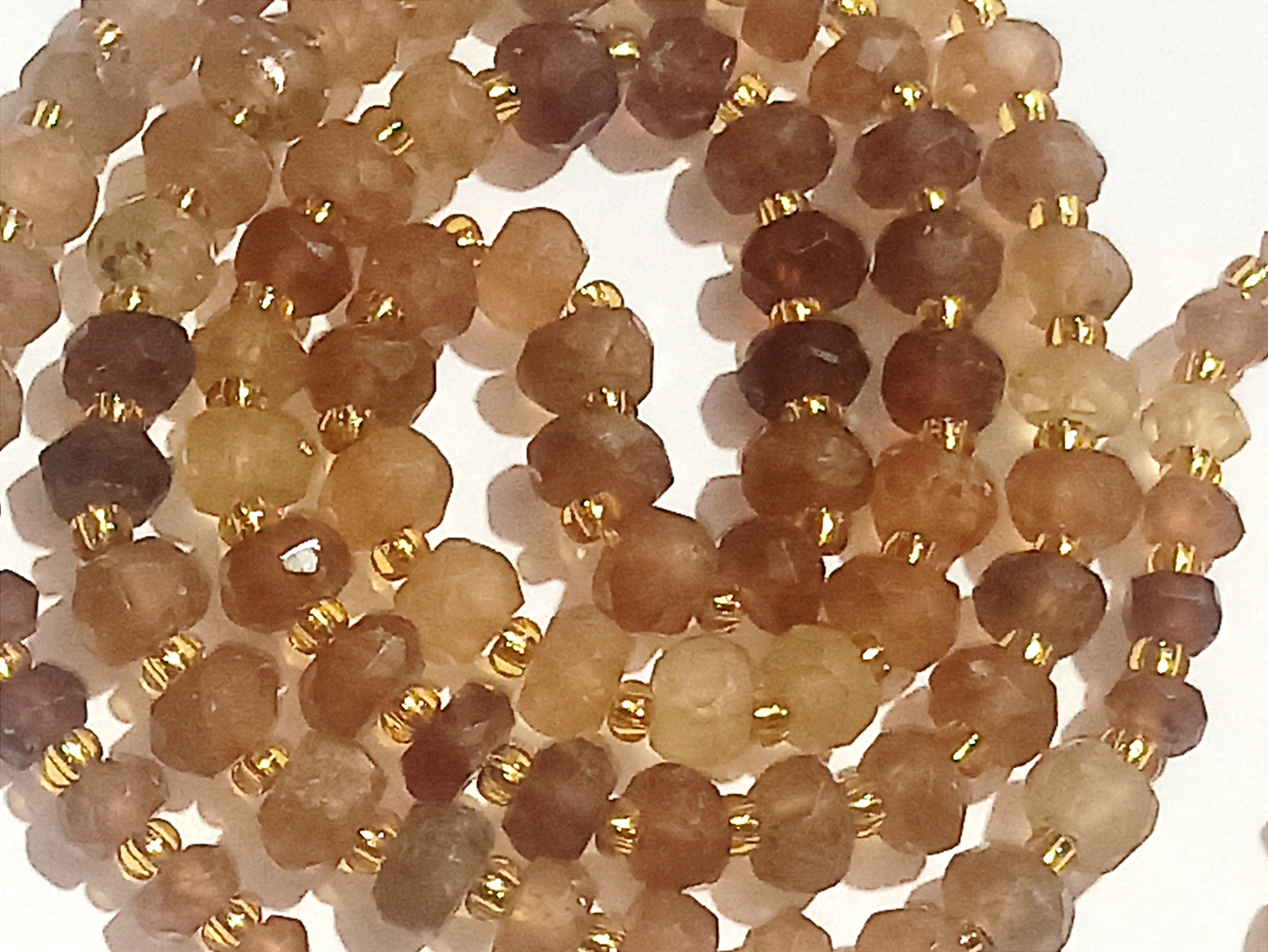 Nahaufnahme: Gomed mala (Hessonite) braune Edelsteinperlen mit goldfarbenen Zwischenperlen