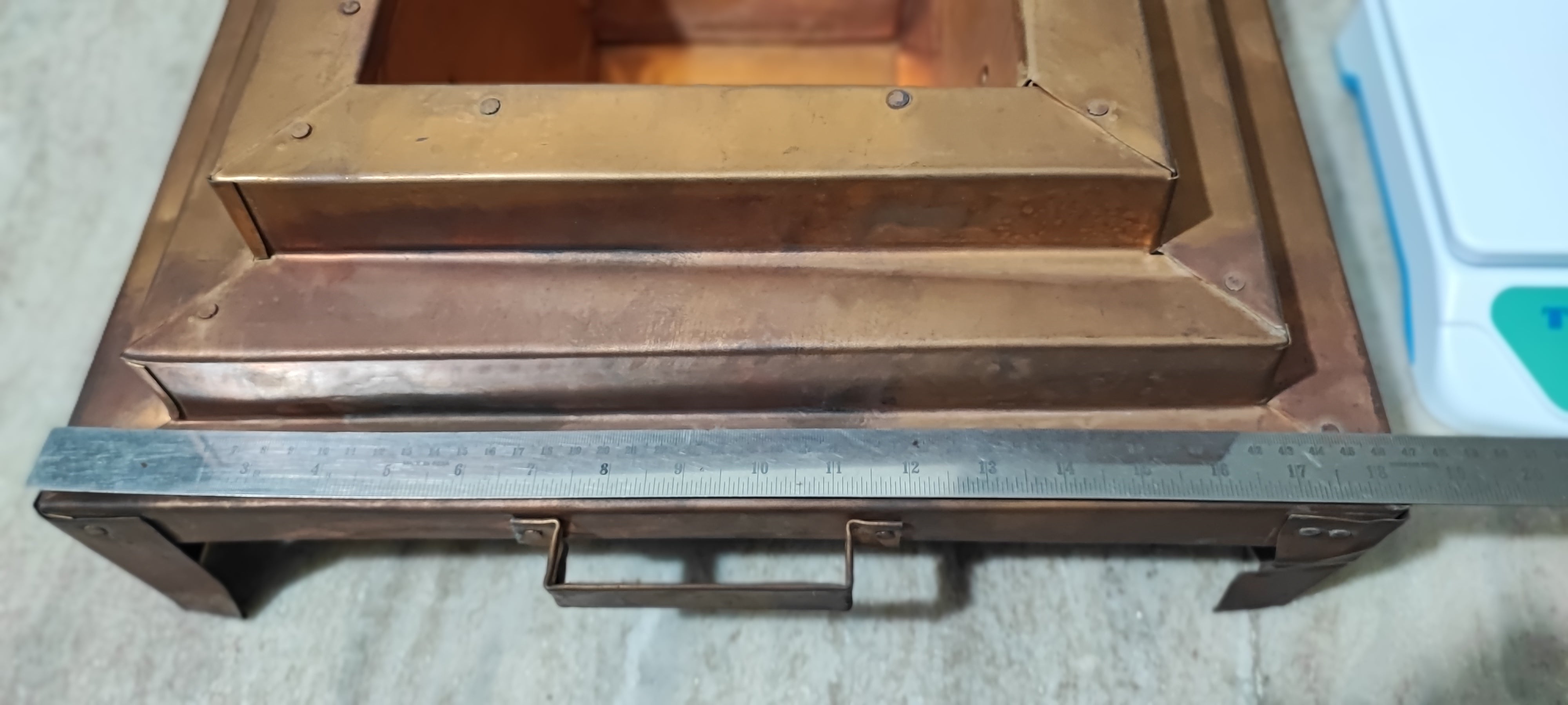 Copper havankunda with metal ruler measuring across the front width