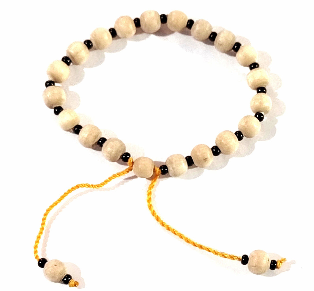 Tulsi-bead adjustable wristband with beige beads and orange tie ends