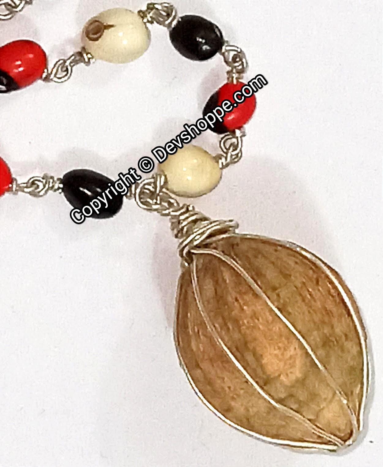 Chirmi mala close-up: red, black, white beads on silver links with leaf pendant