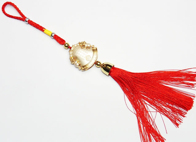 Gold bell charm with laughing Buddha design and red tassel on hanging cord