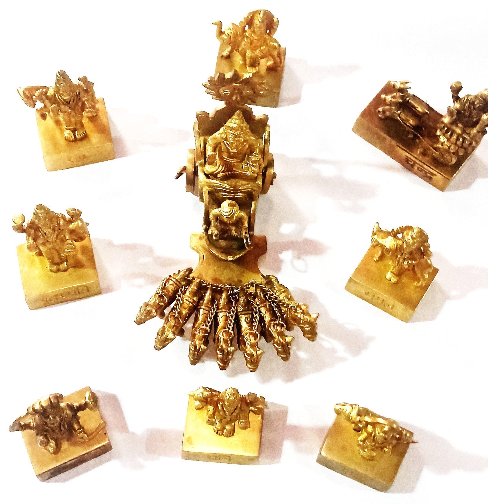 Navagraha idol set featuring a central golden seated deity with surrounding figures