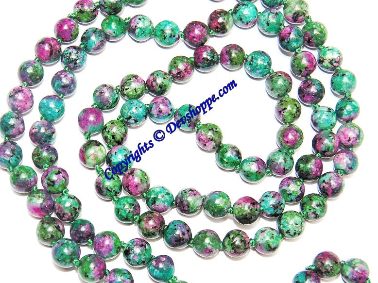 Close-up of round ruby zoisite beads in green and pink with metallic sheen