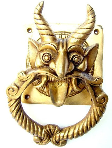 Brass demon-faced door knocker with circular mouth ring