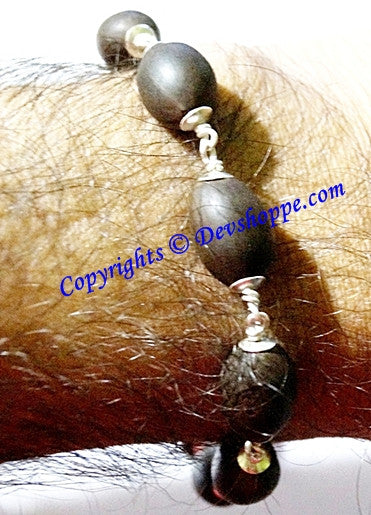 Lotus seed bracelet on wrist: dark beads with silver caps and clasp links