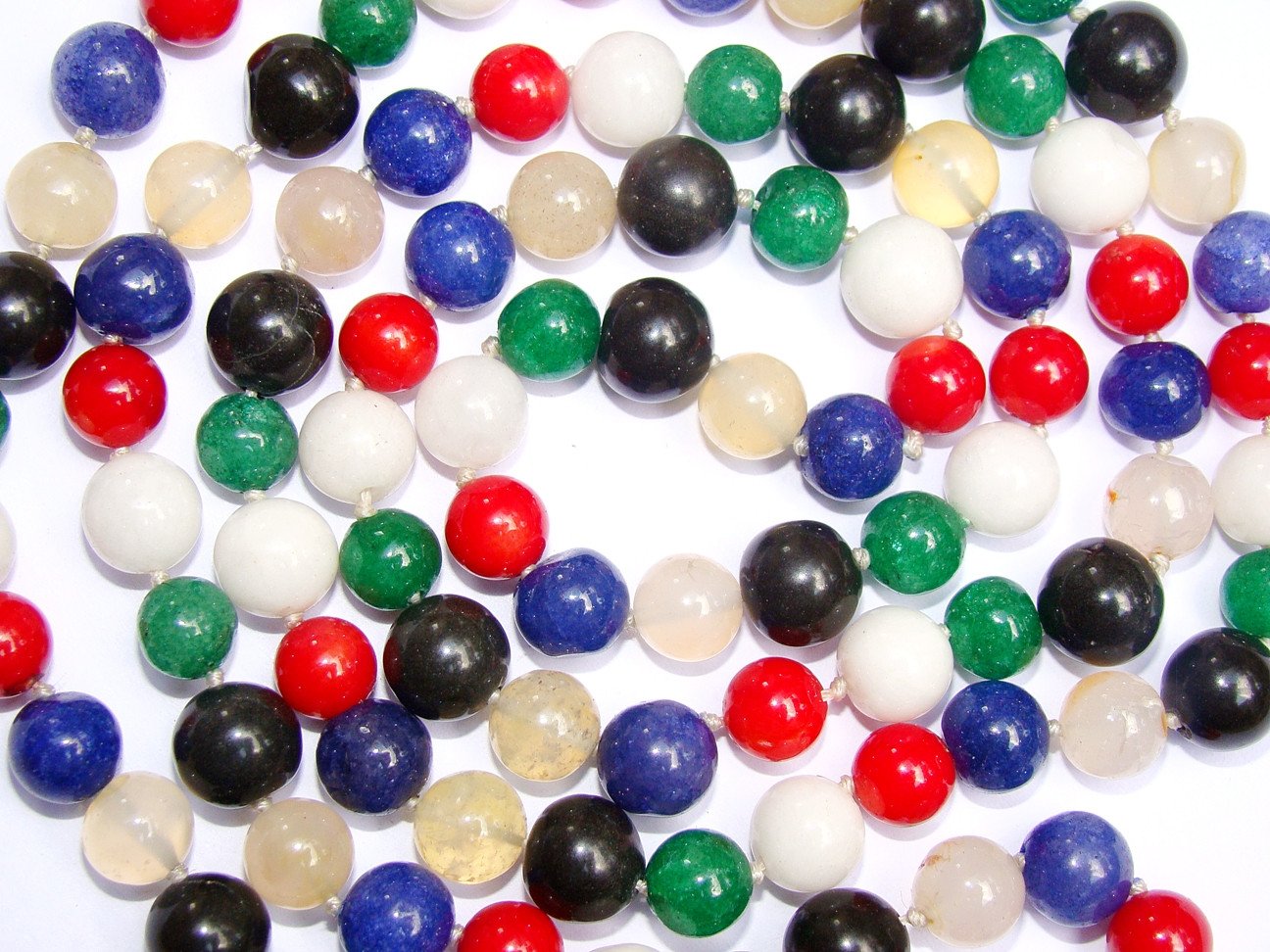 Close-up mixed agate beads in white, red, blue, green, black, and cream