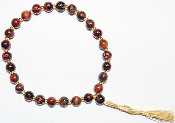 Red tiger eye wrist mala with round reddish-brown beads and gold tassel