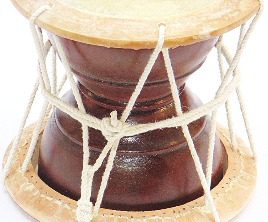 Deru hand percussion drum, close view of dark wooden body and white rope cords