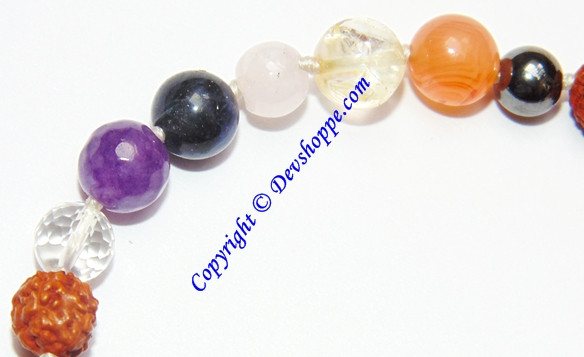 Handcrafted bracelet with orange, purple, black, and clear multi-stone beads and gold centerpiece