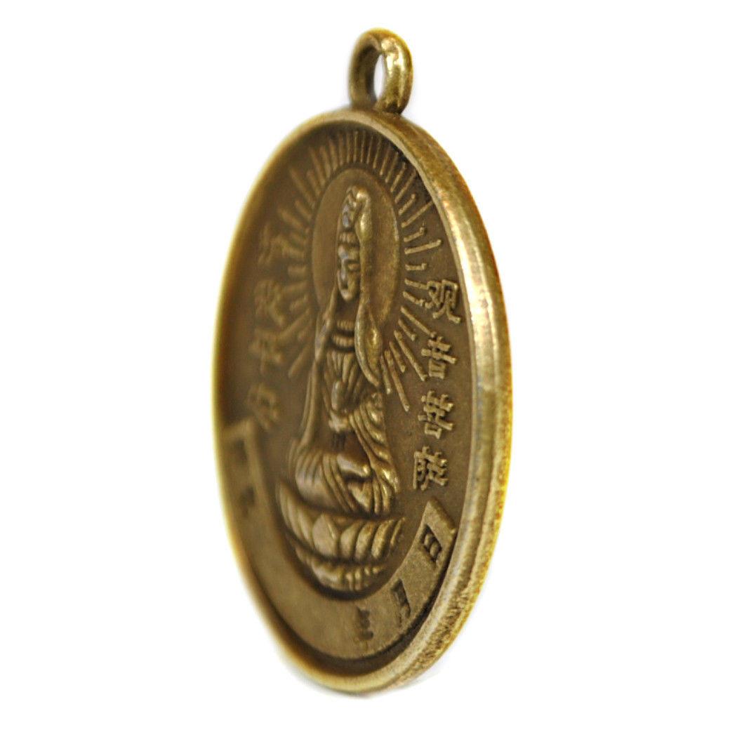 Oval gold charm coin side view with hanging loop, seated figure and Chinese characters