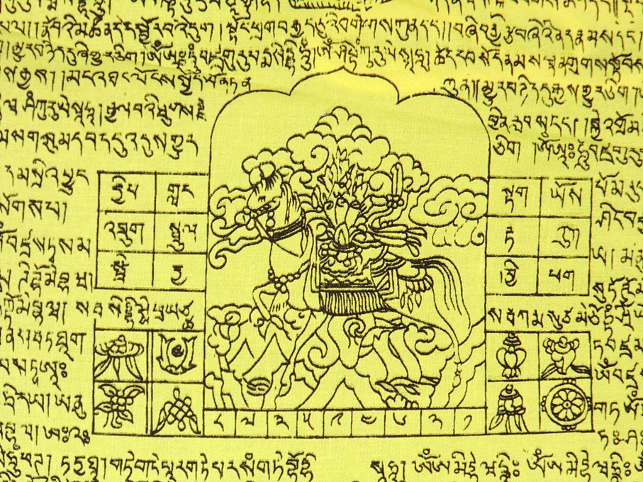Close-up of Tibetan windhorse prayer flag panel with yellow Tibetan script and windhorse icon