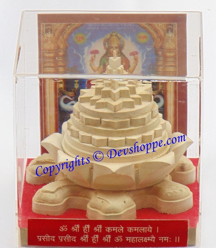 Meru yantra on tortoise base, cream/golden carving with central spired geometric design
