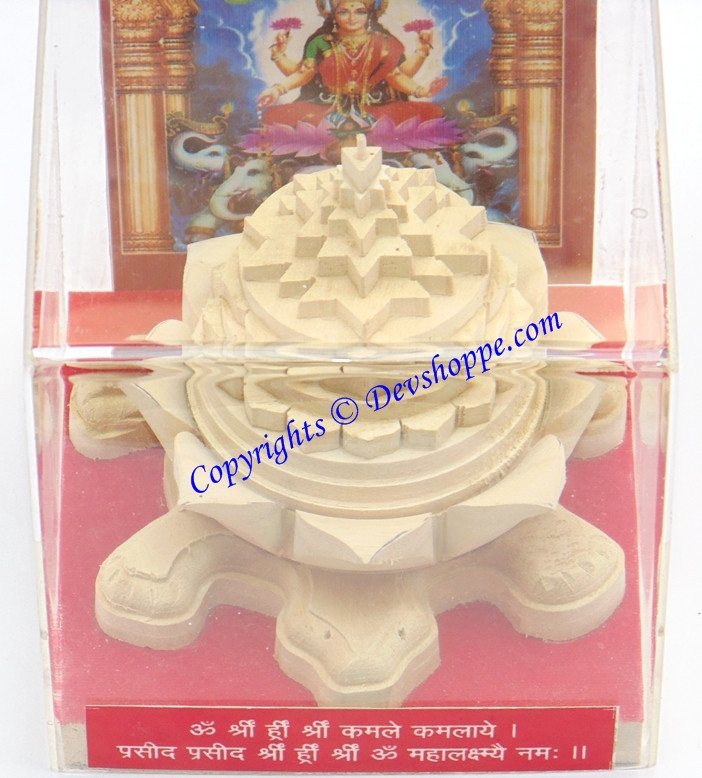 Meru yantra on tortoise pedestal, cream stone-like carving with layered circular pattern
