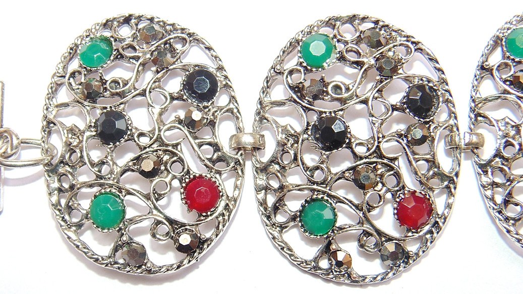 Tribal-Armband: zwei ovale Anhänger mit filigranen Ornamenten und grünen, roten, schwarzen Steinen