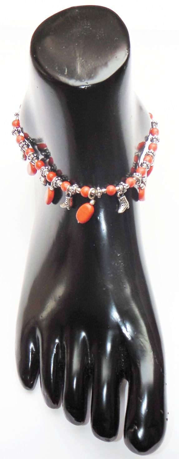 Beaded anklet on black display hand: orange beads with silver charm pendants