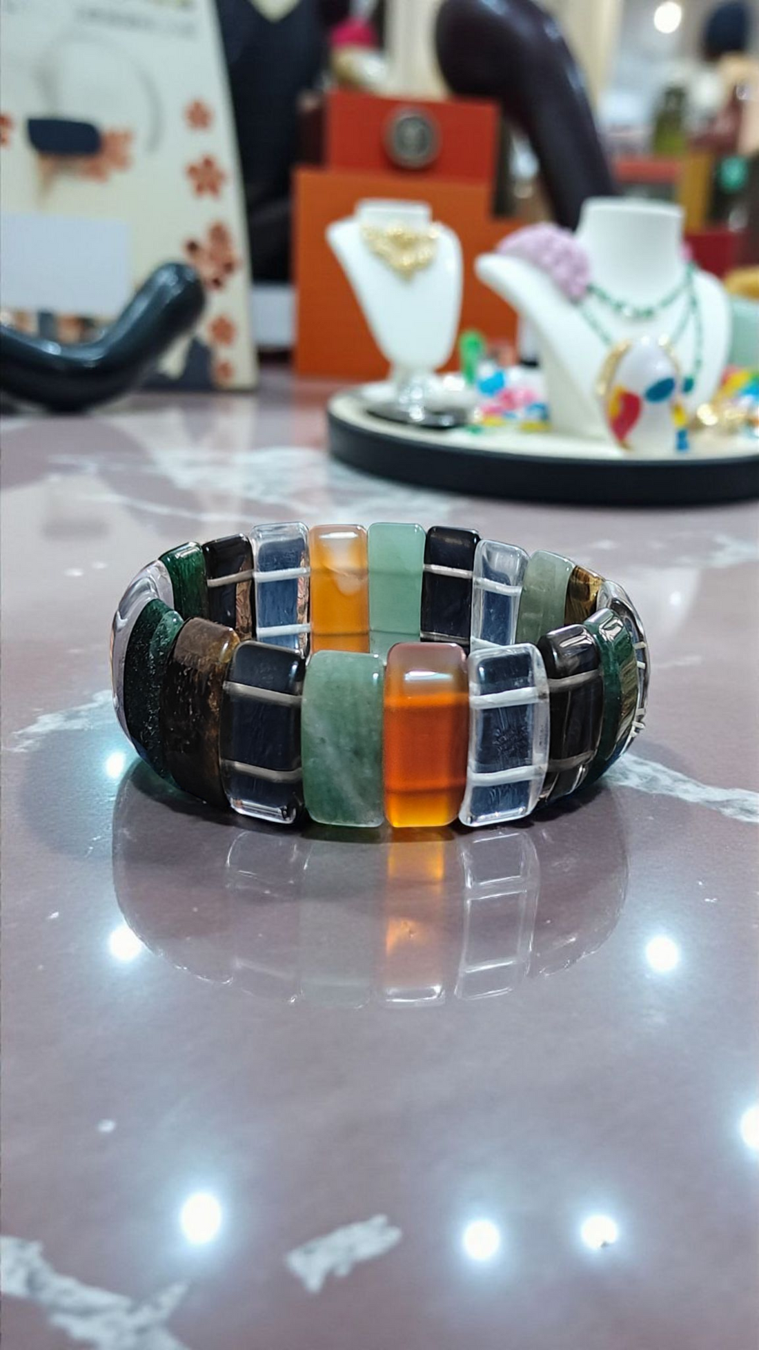 Multi-stone beaded bracelet with rectangular glass segments in green, orange, black shades
