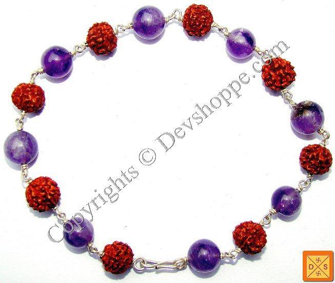 Silver bracelet with purple amethyst-look beads, red textured beads, and chain links.