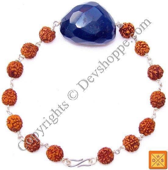 Pulsera combinada con dije azul facetado y cuentas anaranjadas tipo rudraksha, eslabones plateados