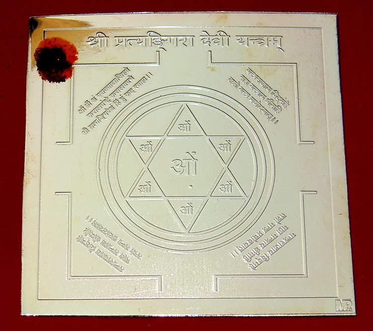 Brass yantra plate with circular protective geometry and centered triangle with ॐ symbol