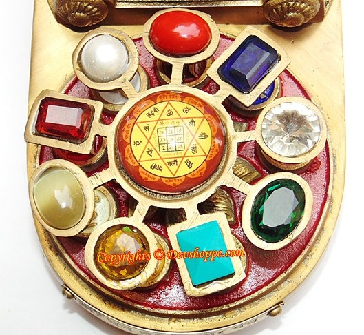 Yantra chowki top view with colored gemstone tiles and central golden-red yantra disc