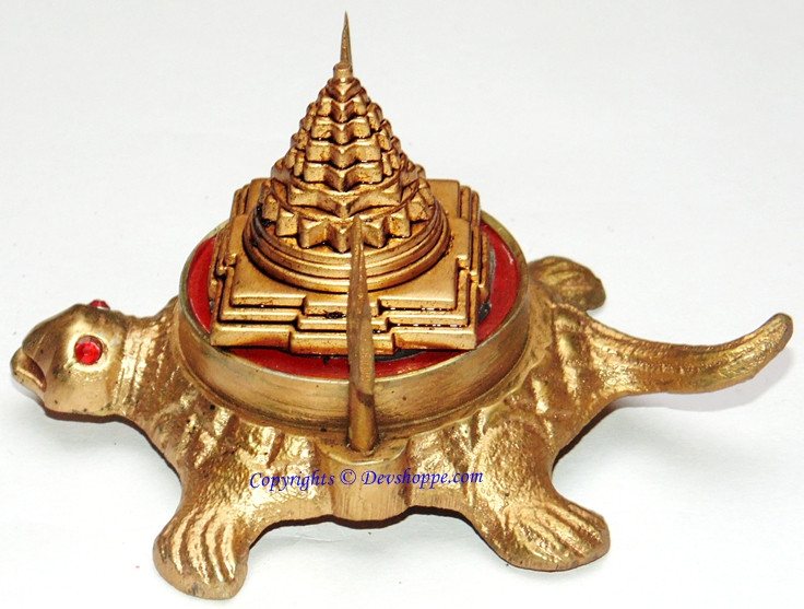 Brass Shri Yantra on tortoise with red center panel and vertical trident finial