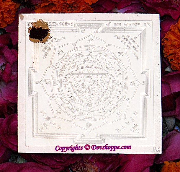 Sri Dhana Akarshan yantra diagram on pale sheet, ornate circular geometry with text
